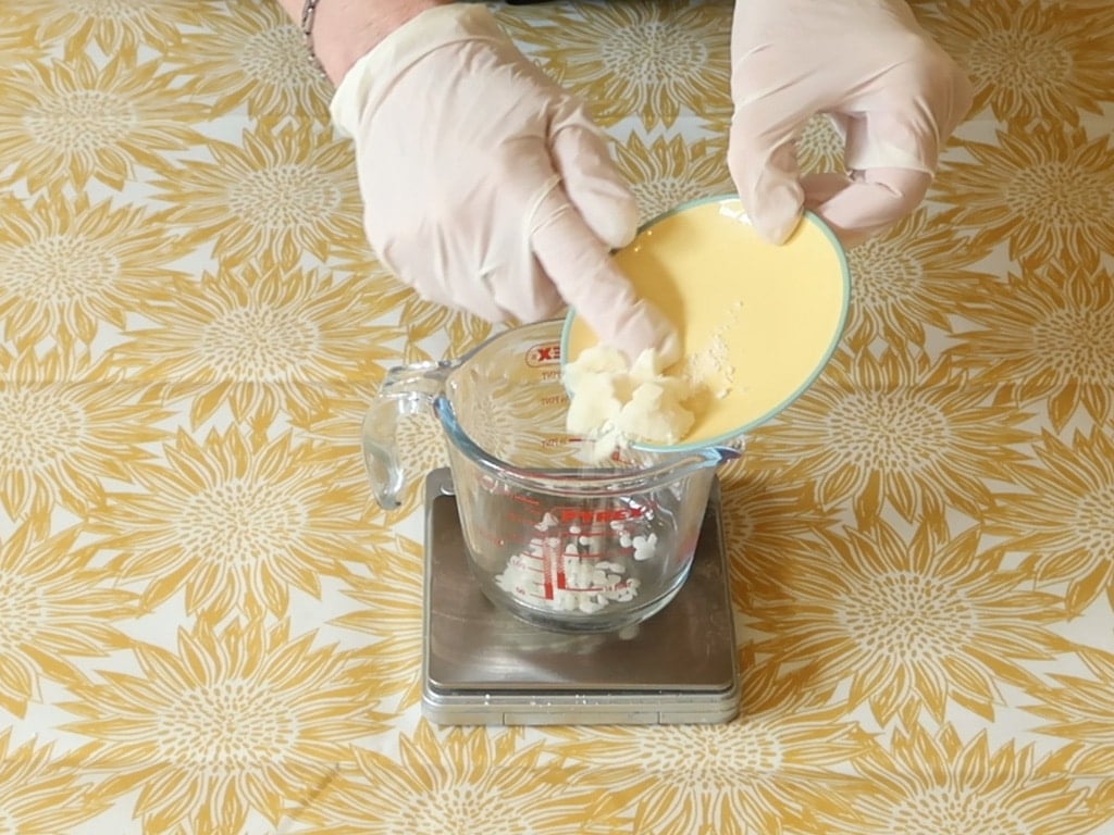 Weigh the oil, cocoa butter, shea butter, beeswax, and emulsifying wax into a separate heat proof container.