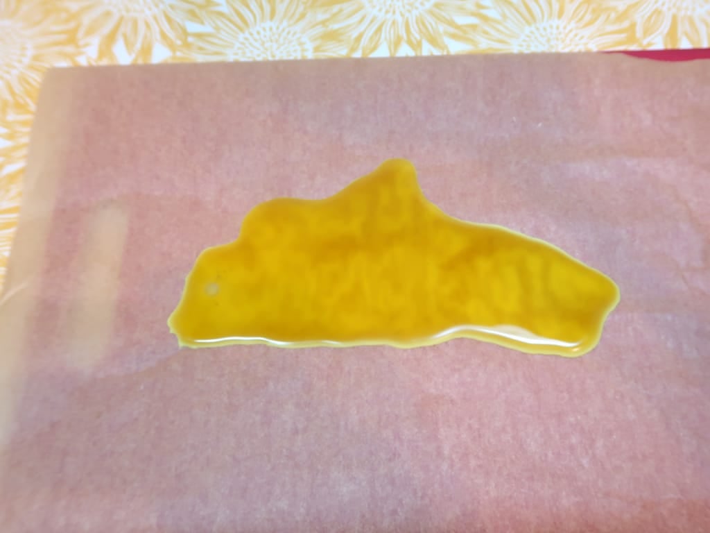 Step 3: Pour the hot wax onto some baking parchment, allow to cool but not harden so it is still flexible