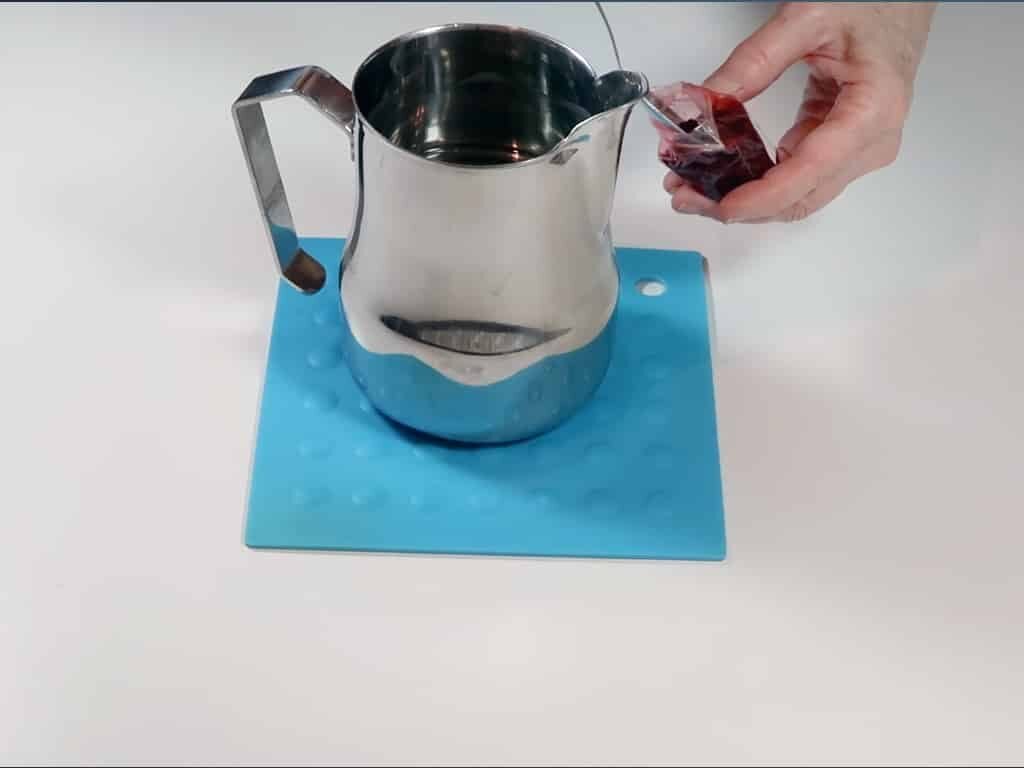 Candle dye being added to freshly melted wax