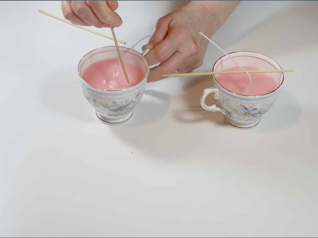 A woman poking holes into the tea cup candle