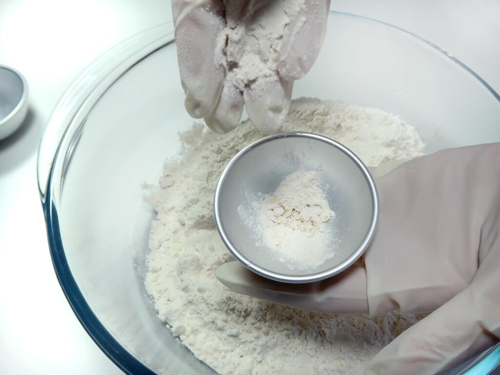 A woman fills a bath bomb mold with mixture