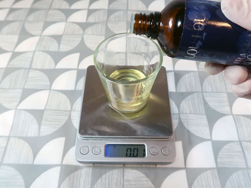 A woman weighs fragrance oil