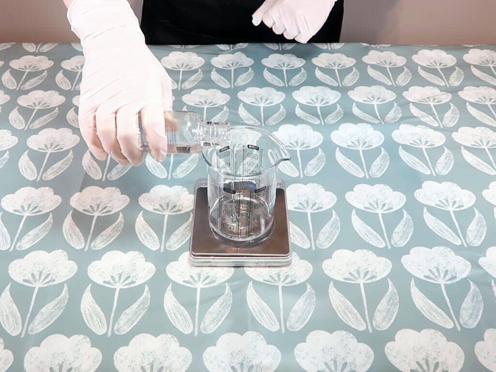 Hydrosol being added to a heatproof, pyrex beaker sitting on a set of digital weighing scales