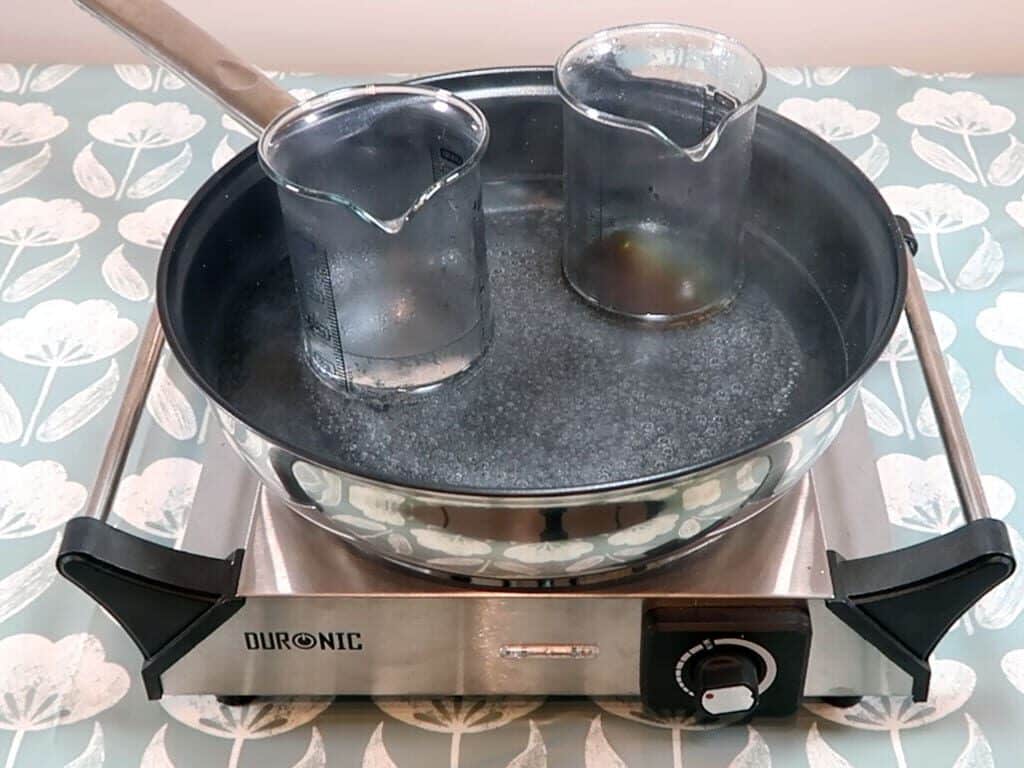 Two beakers sitting in a double boiler after 20 minutes