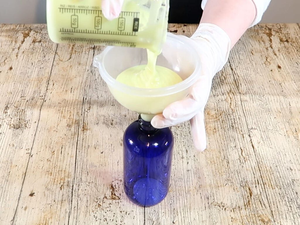 The emulsion is passed through a funnel and into a blue tinted, PET plastic bottle