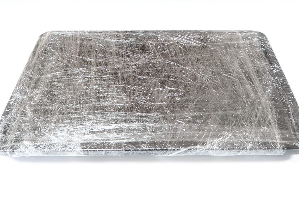 Two baking trays wrapped in plastic wrap