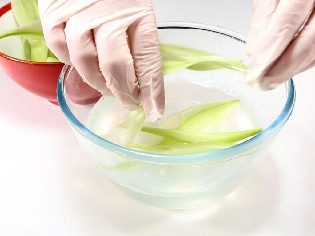 Petals being submerged into liquid coconut oil