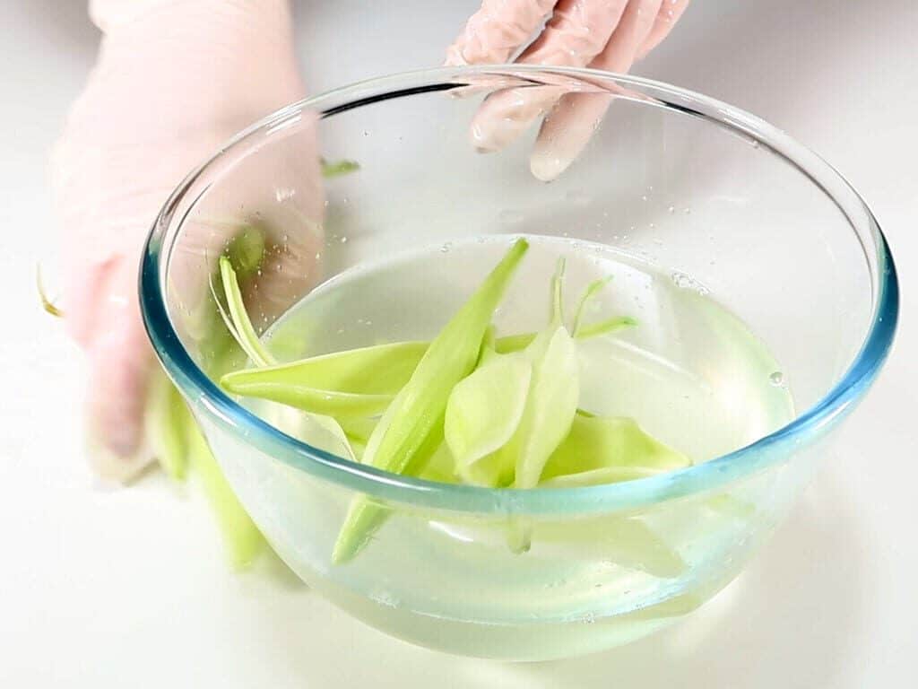 Petals being added to liquid coconut oil