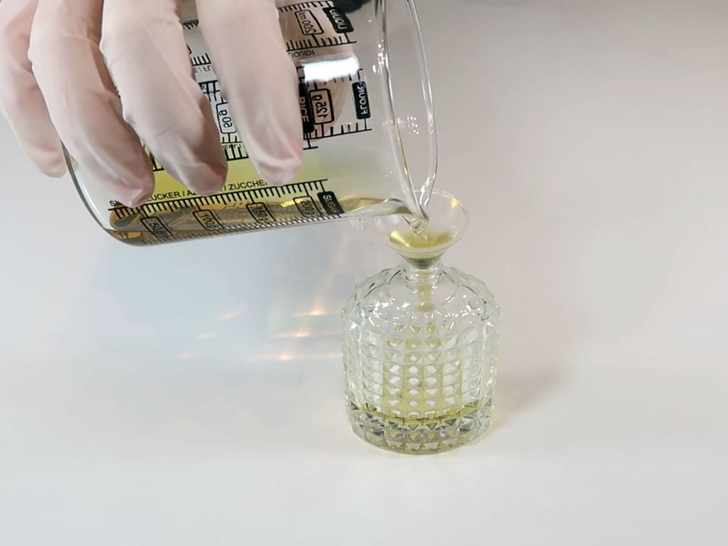 The perfume is poured into a 30ml glass perfume bottle, using a funnel