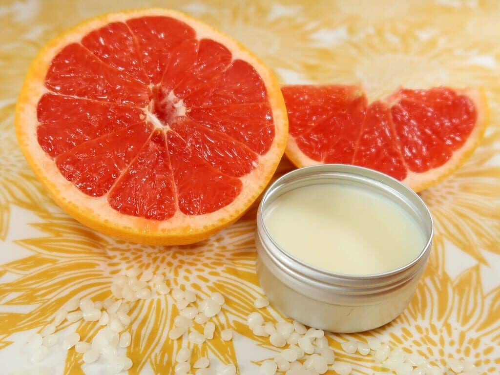 DIY solid perfume, pictured next to some grapefruit