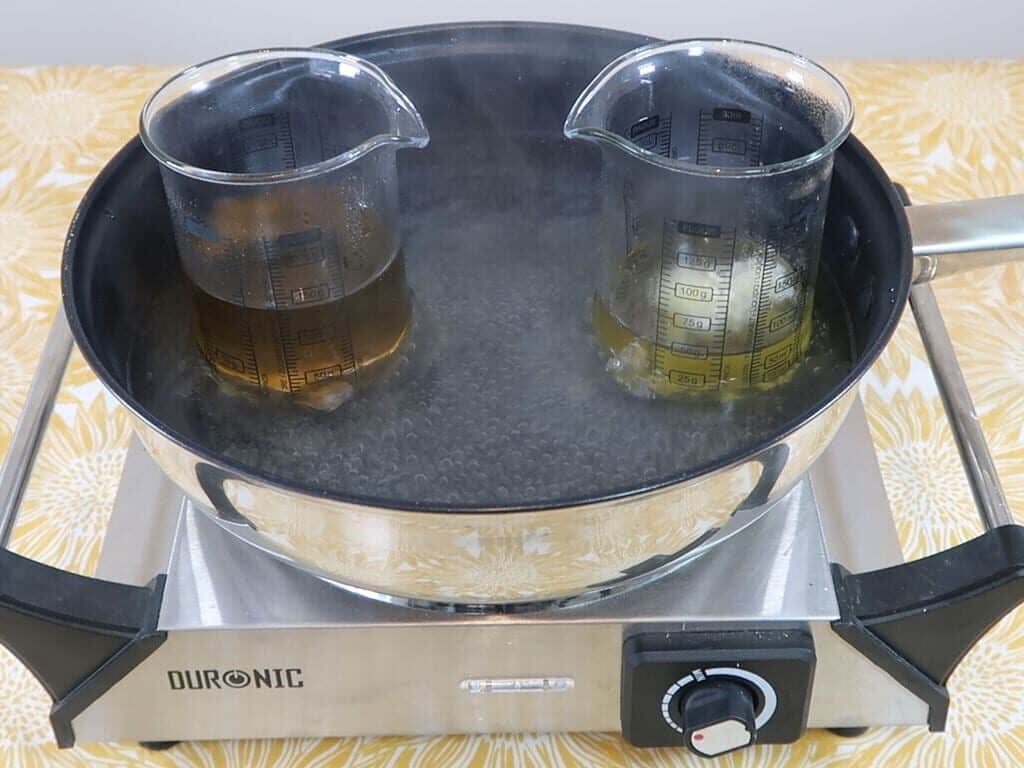 Oil and water phase beakers being heated in a water bath