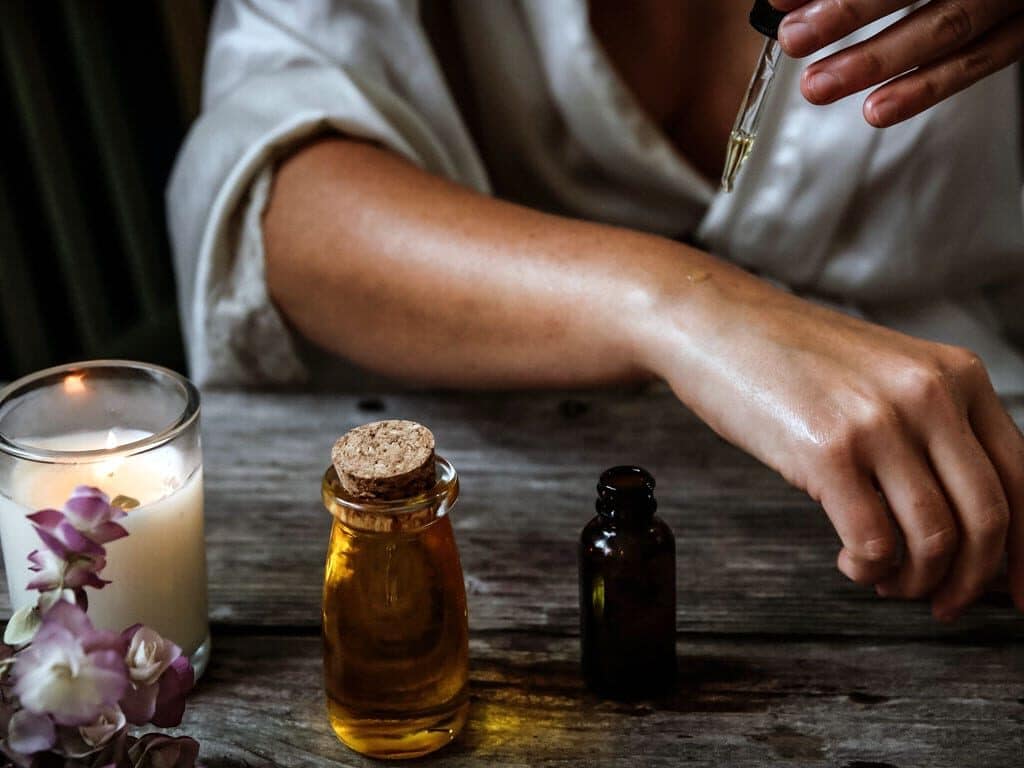 A woman applies an oil based perfume to her skin