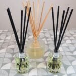 3 reed diffusers sit on a table