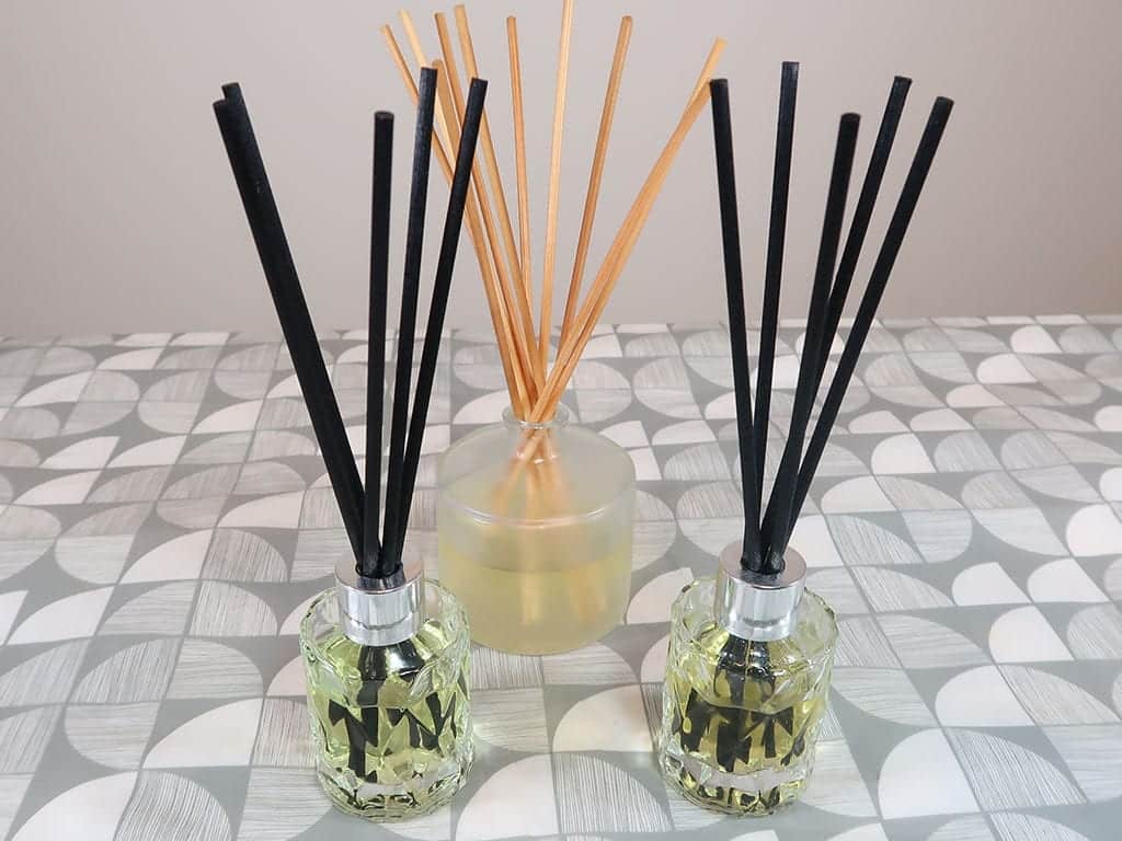 3 reed diffusers sit on a table