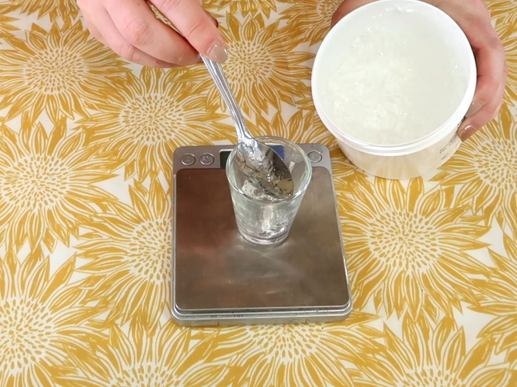 Aloe vera gel is measured in a small glass beaker