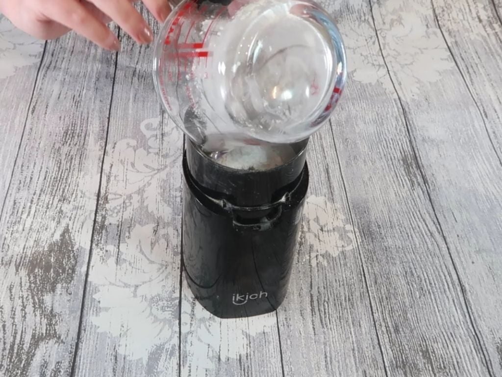 The powdered base ingredients are added to the coffee grinder