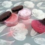 Two powdered blushes sit next to a blusher brush