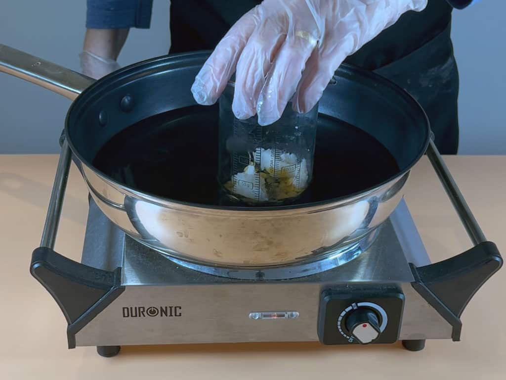 Place the beaker into a water bath or bain marie