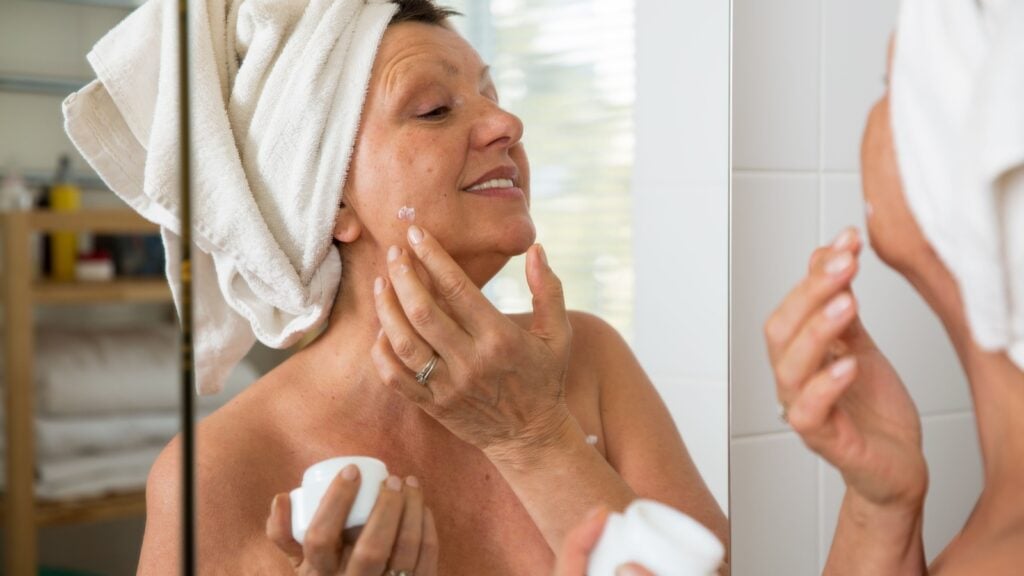 Mature beautiful woman applying moisturizer Mature beautiful woman applying moisturizer