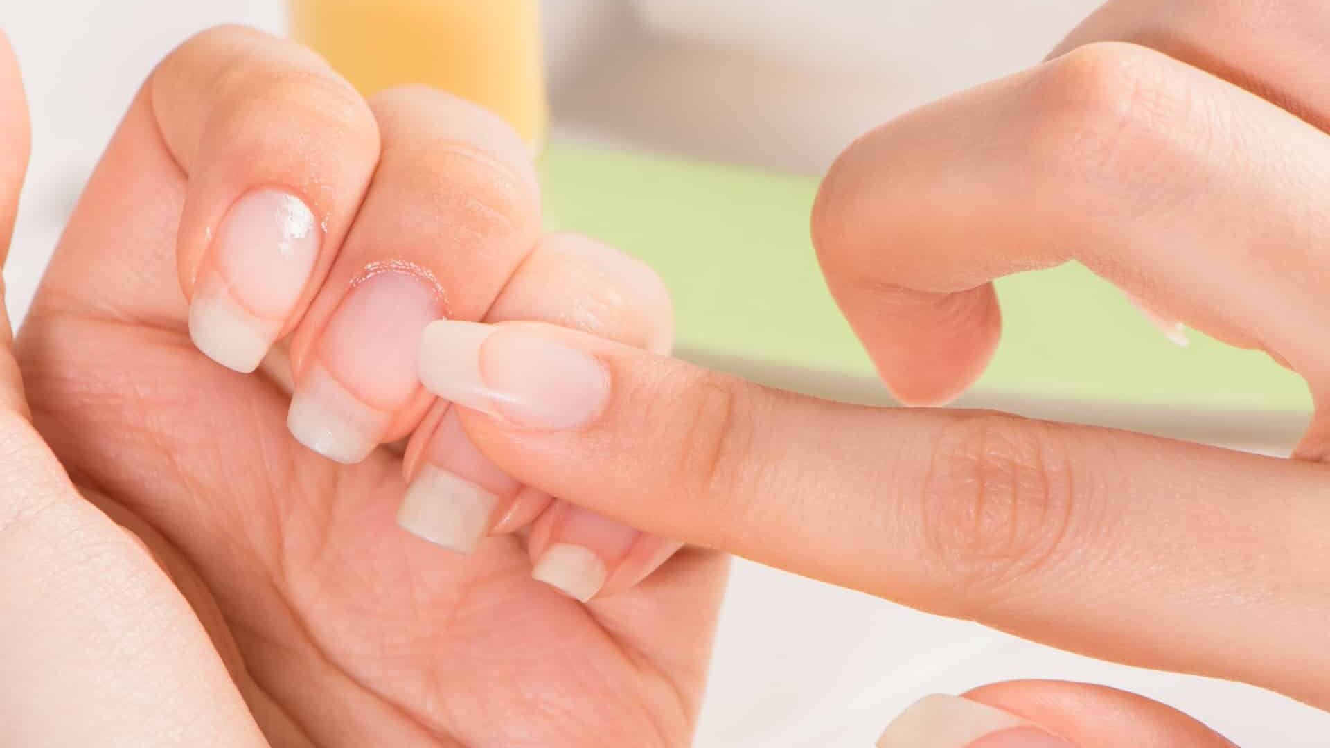 close up of women applying oil to finger nails cuticles close up of women applying oil to finger nails cuticles
