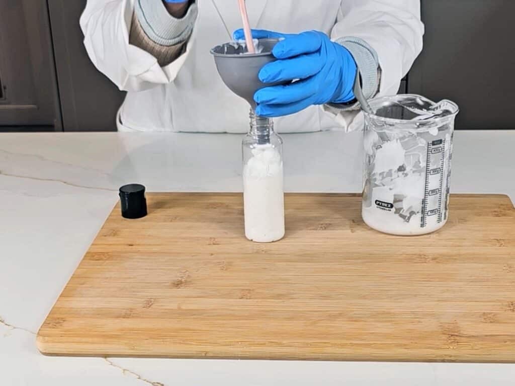 The emulsion is being transferred to a PET plastic bottle to store