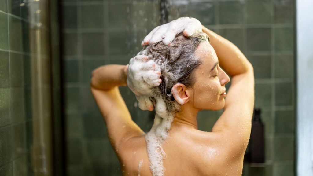 women washing hair with shampoo in the shower