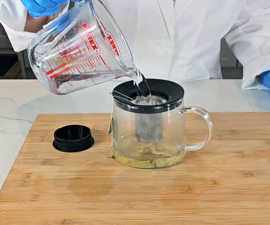 Freshly boiled water is poured into the glass tea pot.