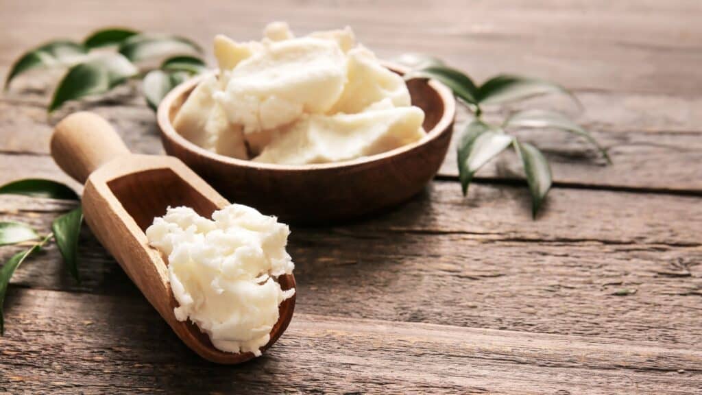 Plate and scoop with shea butter on wooden