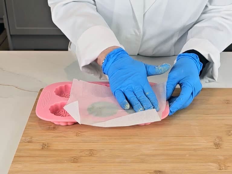 A piece of wax paper is used to smooth the surface of the shampoo bars
