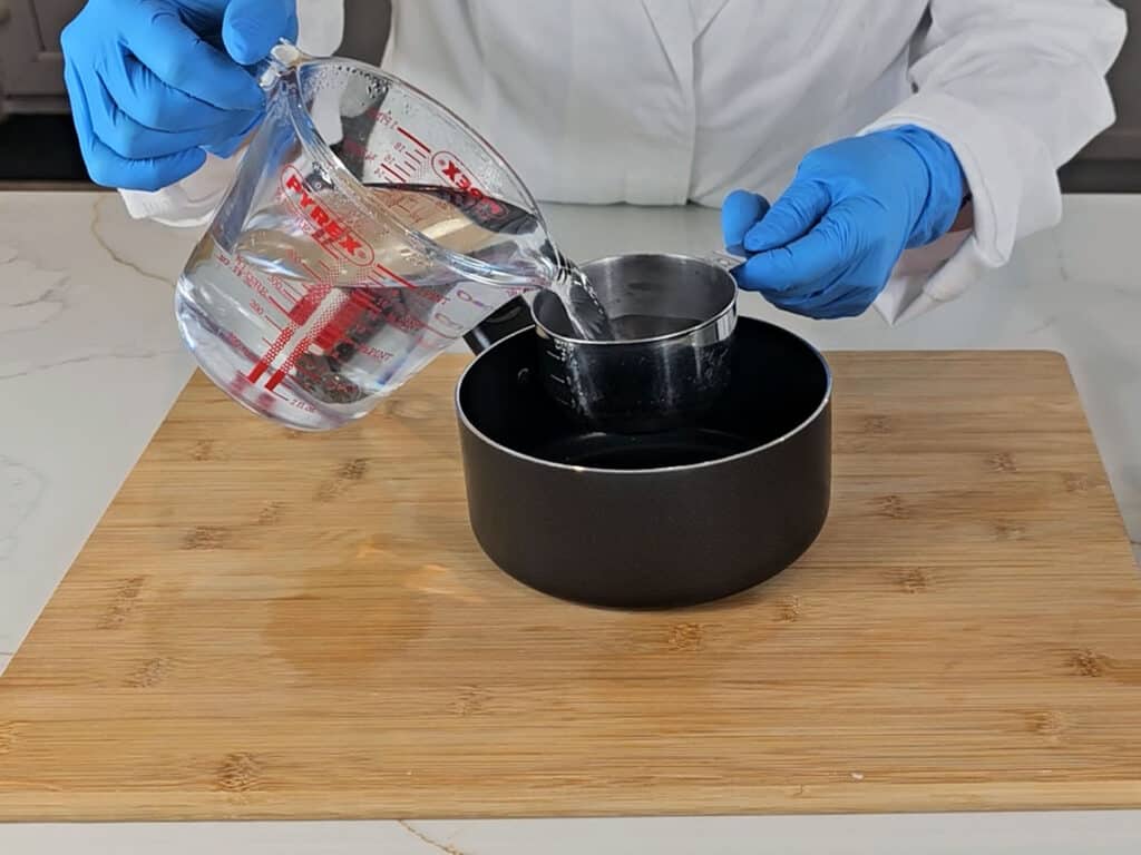 Boiling water is measured into a saucepan