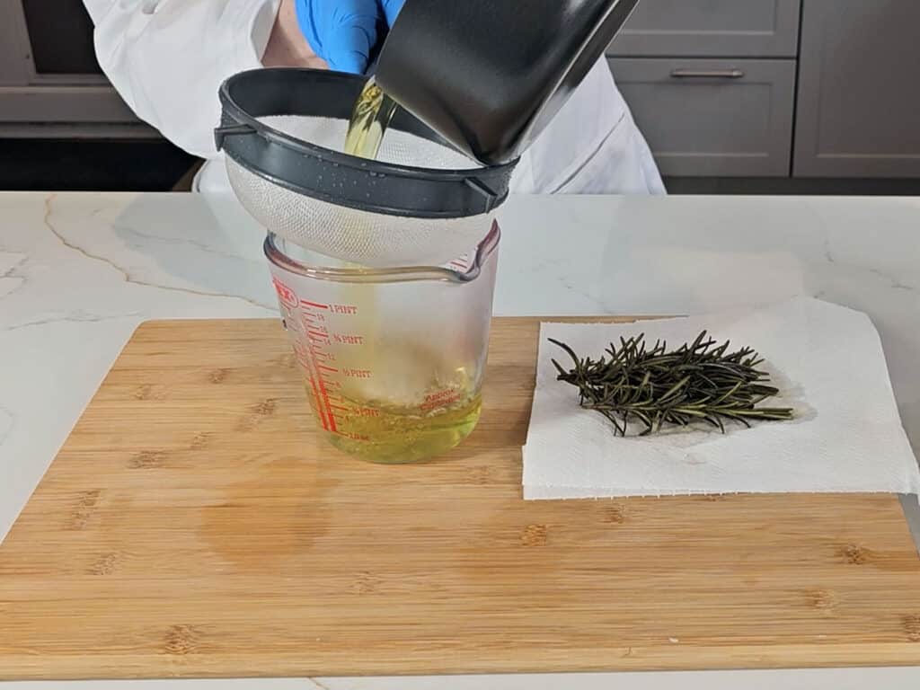 The infusion is sieved into a measuring jug