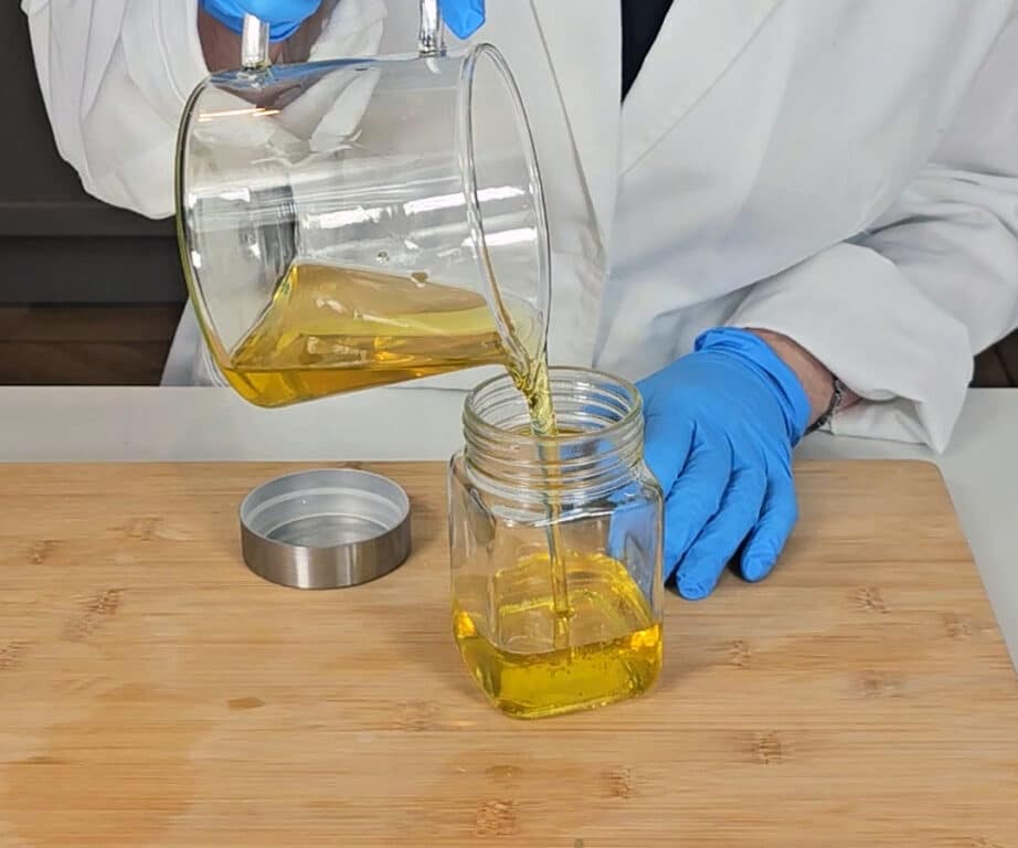 The rosemary oil is poured into a clean mason jar to store