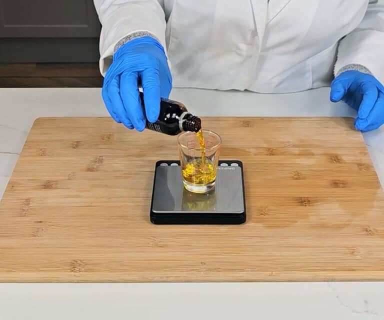 Essential oils are measured into a small glass container