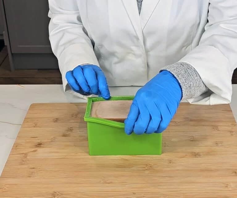 A loaf of turmeric soap sits in a silicon plastic mold waiting to be removed.