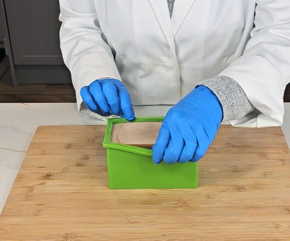 A loaf of turmeric soap sits in a silicon plastic mold waiting to be removed.