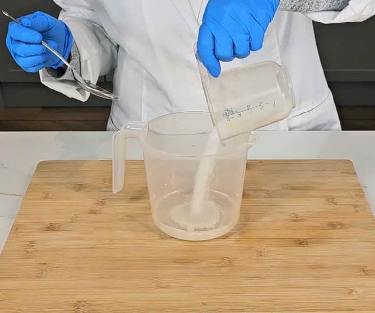 Sodium hydroxide crystals are poured into distilled water to make the lye solution