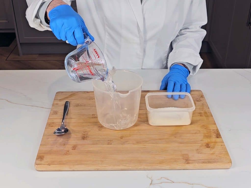 Distilled water is measured into a pouring beaker