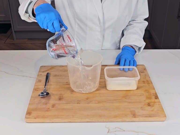 Distilled water is measured into a pouring beaker