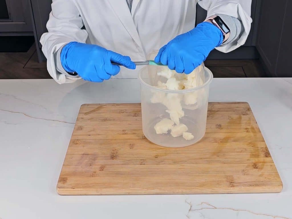 Solid coconut oil and cocoa butter is emptied into a pouring beaker Solid coconut oil and cocoa butter is emptied into a pouring beaker