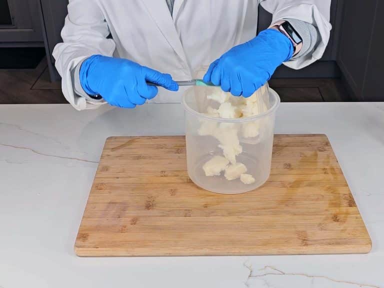 Solid coconut oil and cocoa butter is emptied into a pouring beaker