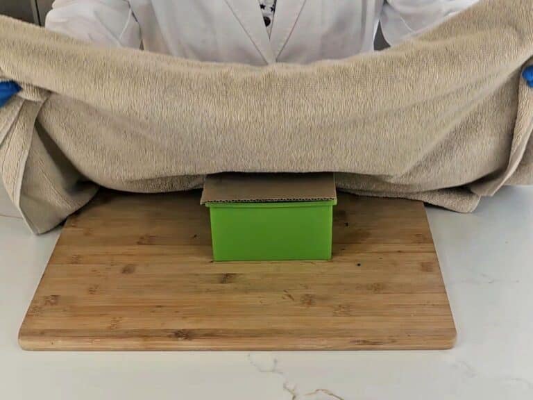 The mold is insulated with cardboard and a towel