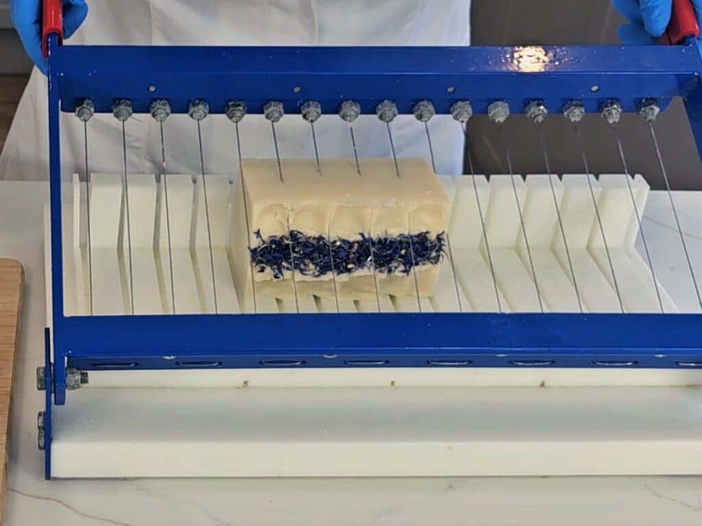 The hardened soap is cut with a soap cutter