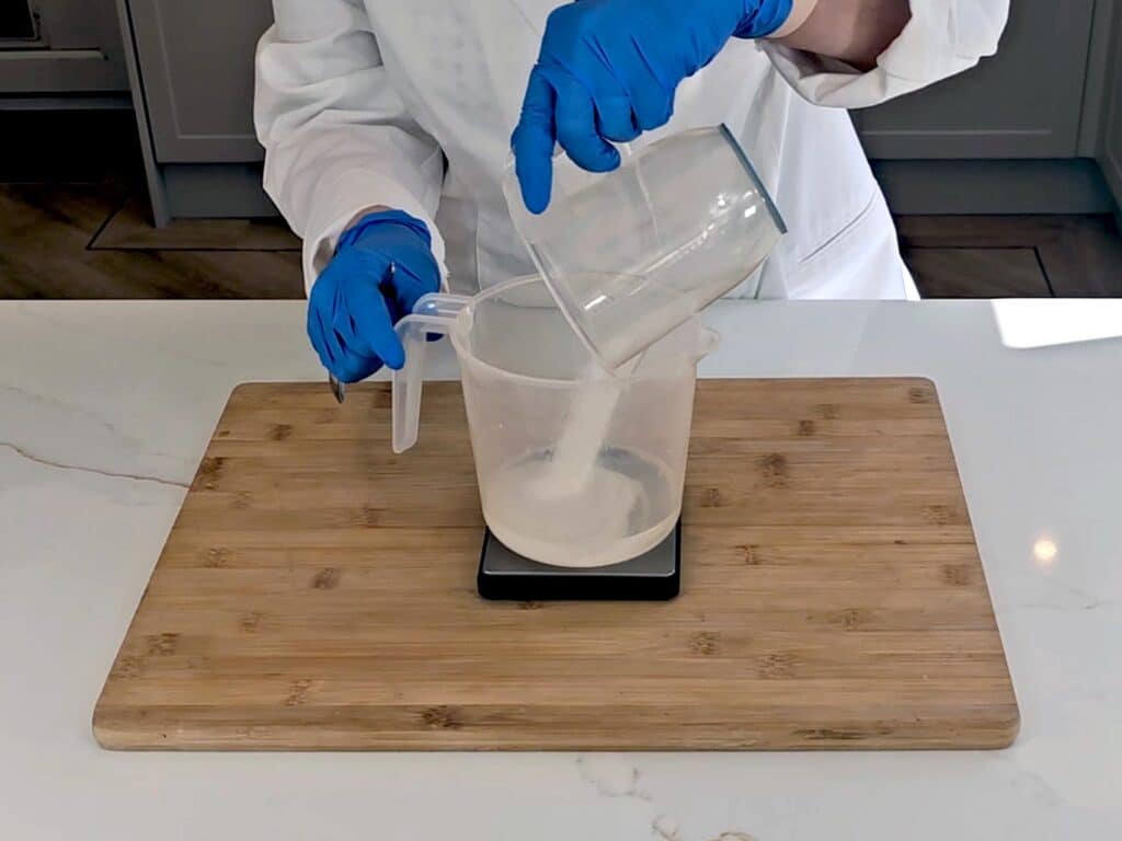 Sodium hydroxide is poured into a pitcher of distilled water