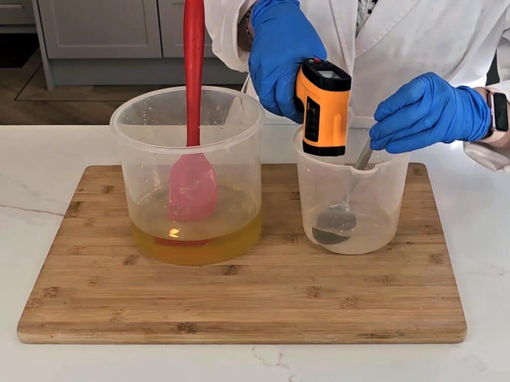 A lazer thermometer is used to measure the temperature of the lye solution