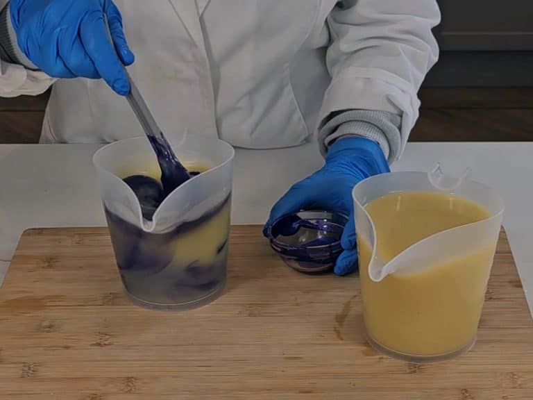 The purple mica is added to one of the jugs and stirred