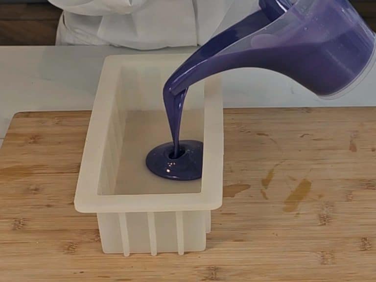 The purple soap batter is poured into the soap mold