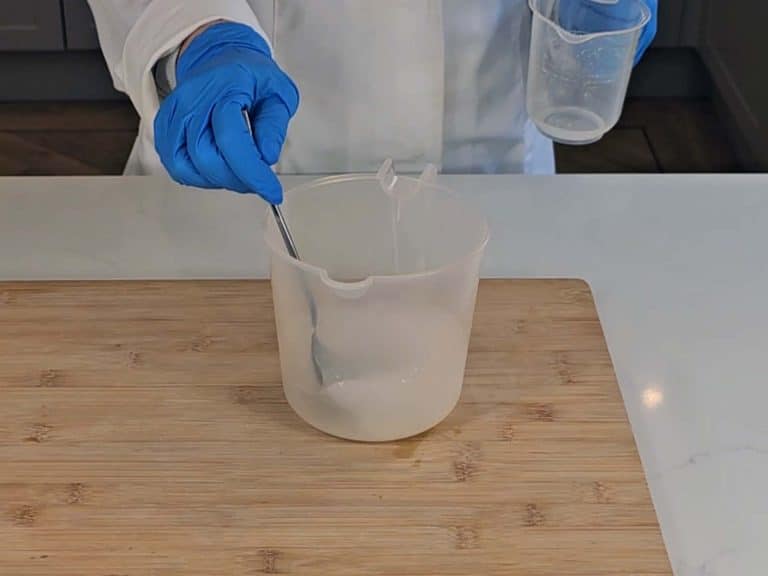 The lye solution is stirred with a spoon