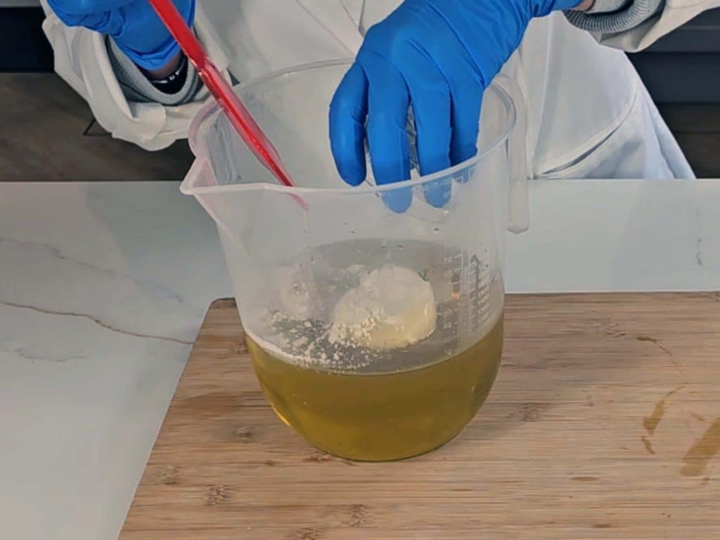 Powdered goats milk is added to the warmed oils