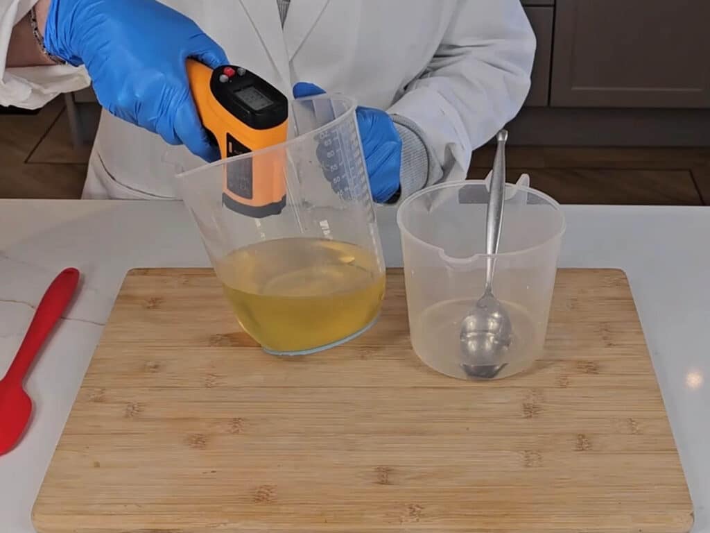 The melted coconut oil is measured with a lazer temperature gun