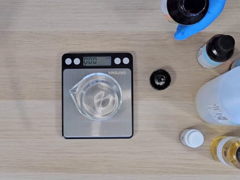 A glass beaker sits on a digital scale with ingredients sat next to it